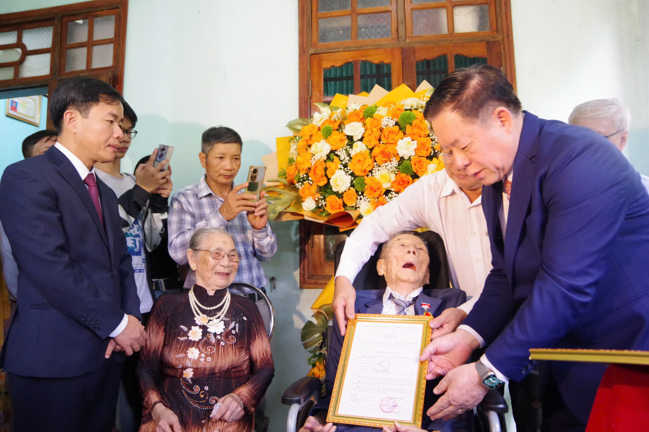 Đại tướng Nguyễn Trọng Nghĩa trao quyết định tặng Huy hiệu Đảng cho đảng vi&ecirc;n Nguyễn Anh H&ugrave;ng. (Ảnh: Xu&acirc;n Diện)