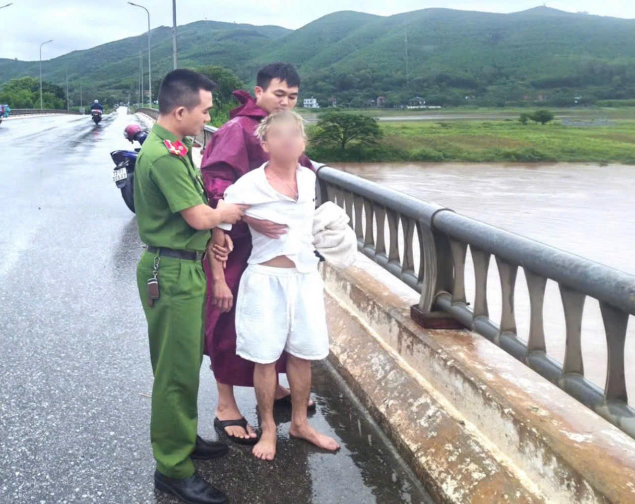 Đại &uacute;y B&ugrave;i Đăng Li&ecirc;m, c&aacute;n bộ C&ocirc;ng an x&atilde; Phong Nha, kịp thời tiếp cận, đưa nam thanh ni&ecirc;n rời khỏi vị tr&iacute; nguy hiểm tr&ecirc;n cầu Xu&acirc;n Sơn. (Ảnh: CA Quảng Trị)