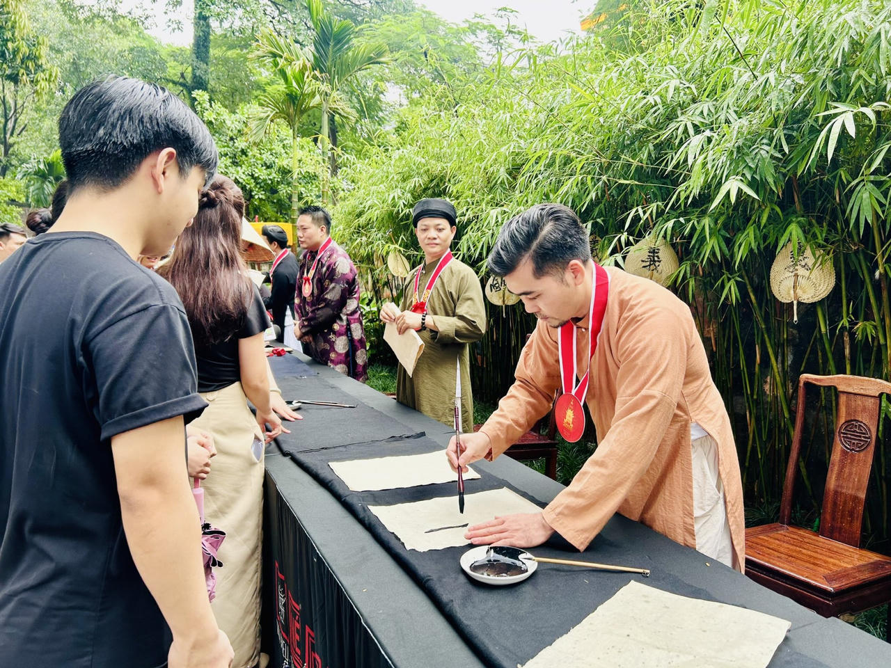 Thay v&igrave; chỉ trưng b&agrave;y t&aacute;c phẩm ho&agrave;n chỉnh, &ldquo;N&eacute;t chữ an nhi&ecirc;n&rdquo; tạo điều kiện để người xem theo d&otilde;i trực tiếp qu&aacute; tr&igrave;nh h&agrave;nh b&uacute;t (Ảnh: Th&ugrave;y Dương).