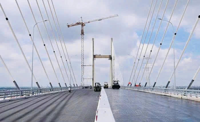 C&ocirc;ng nh&acirc;n khẩn trương ho&agrave;n thiện sơn vạch kẻ đường v&agrave; hệ thống an to&agrave;n giao th&ocirc;ng tr&ecirc;n cầu Phước Kh&aacute;nh. Ảnh: DK