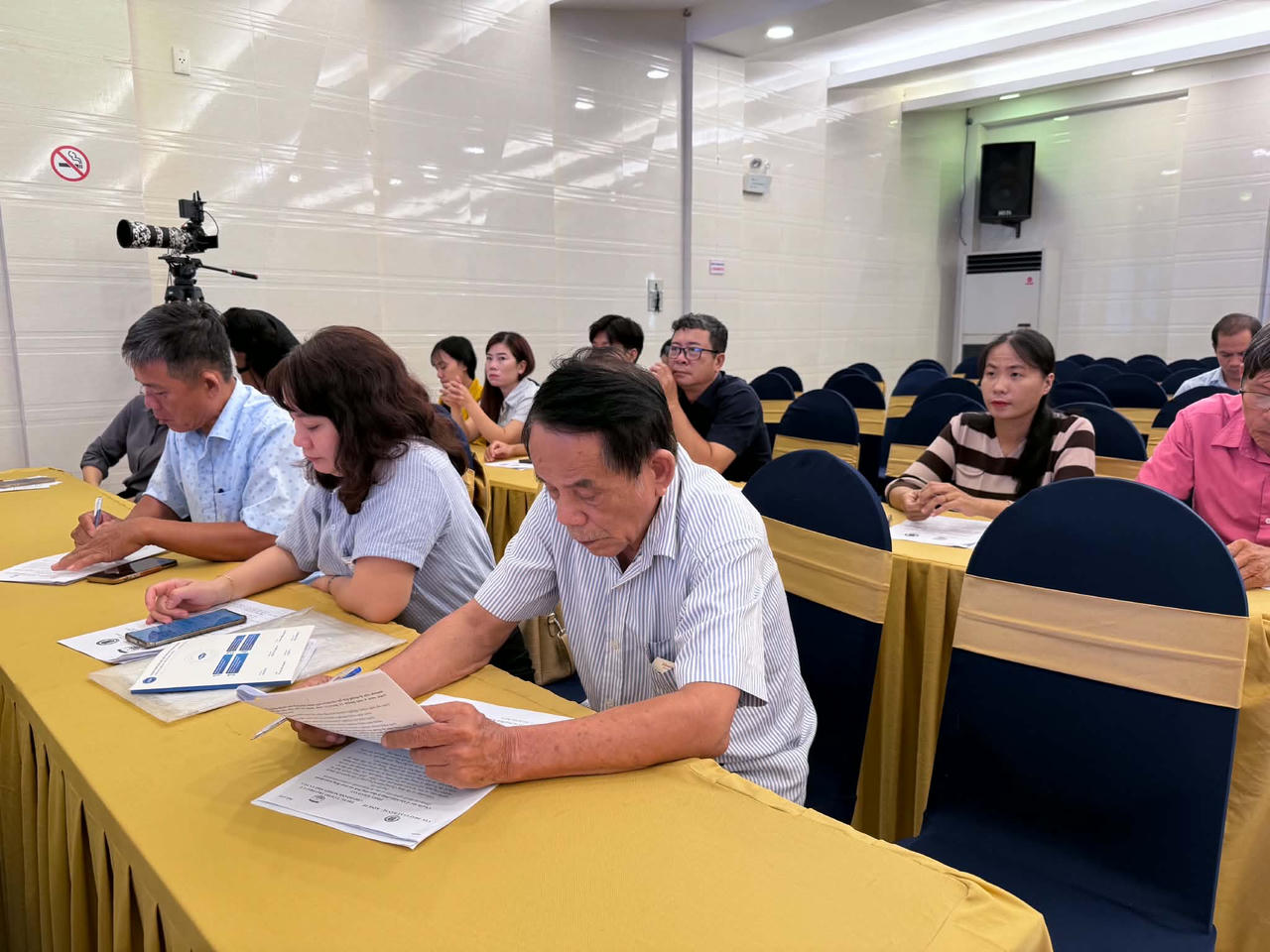 Đại diện c&aacute;c doanh nghiệp, hộ kinh doanh nghi&ecirc;n cứu t&agrave;i liệu về c&aacute;c quy định ph&aacute;p luật li&ecirc;n quan đến lao động, tiền lương v&agrave; BHXH tại hội nghị. (Ảnh: T.Nhung)