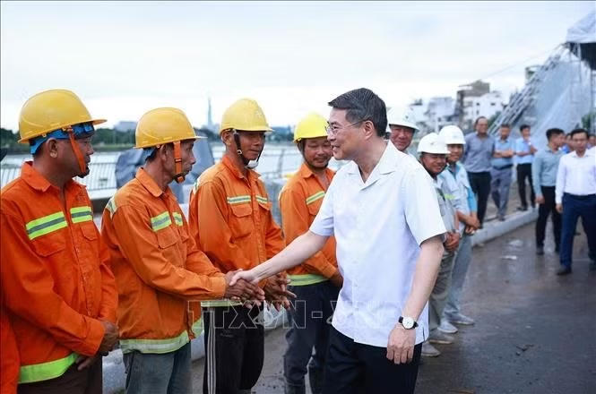 Thủ tướng L&ecirc; Minh Hưng với c&ocirc;ng nh&acirc;n, kĩ sư thi c&ocirc;ng Dự &aacute;n x&acirc;y dựng hạ tầng v&agrave; cải tạo m&ocirc;i trường k&ecirc;nh Tham Lương - Bến C&aacute;t - Rạch Nước L&ecirc;n, tại phường An Nhơn. Ảnh: Dương Giang/TTXVN